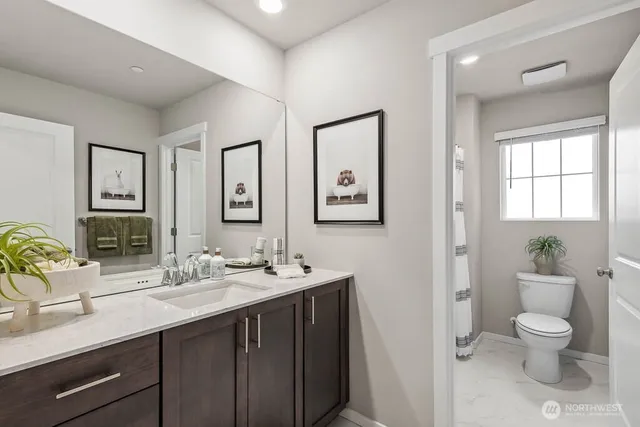 a bathroom with a double vanity sink toilet and a mirror