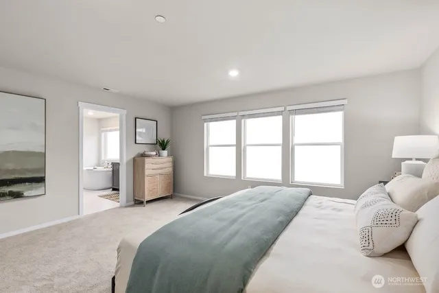 a spacious bedroom with a large bed and a flat tv screen on dresser