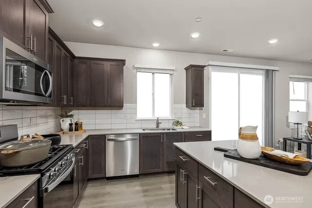 a kitchen with stainless steel appliances granite countertop a sink stove and cabinets