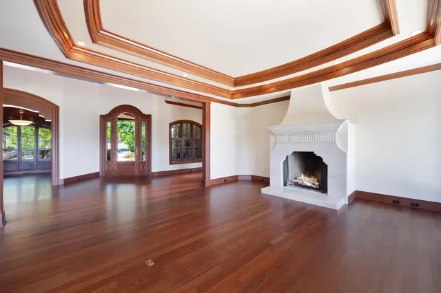 a living room with stainless steel appliances furniture a flat screen tv and a floor to ceiling window
