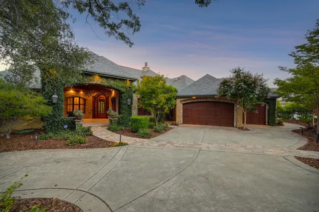 a view of a chairs and table in the patio in front of a house
