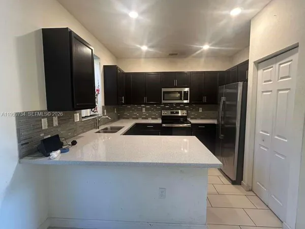 a kitchen with stainless steel appliances a refrigerator sink and cabinets