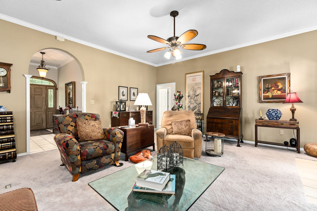 365 Calihan Road Booneville, AR 72927 - Photo 31 of 59 Carpeted living area featuring a ceiling fan, crown molding, and an arched doorway with decorative pillars