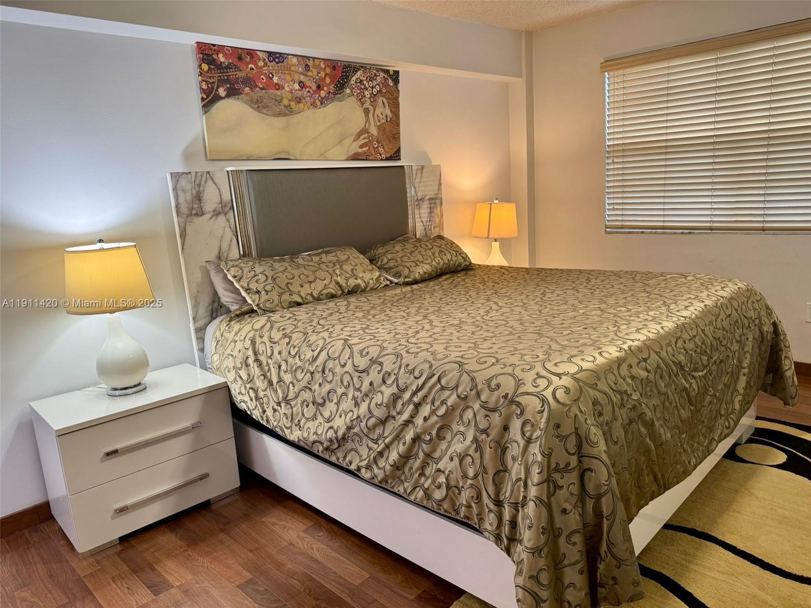 201 180th Drive, Unit 114 Sunny Isles Beach, FL 33160 - Photo 15 of 29 a bed sitting in a bedroom next to a lamp
