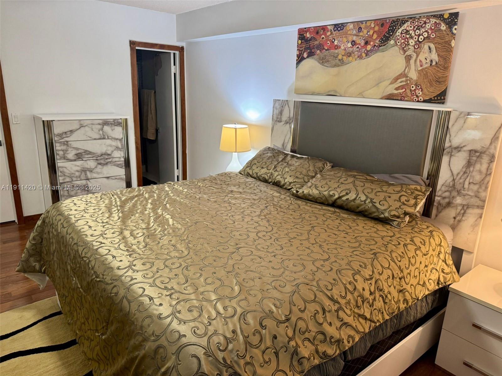 201 180th Drive, Unit 114 Sunny Isles Beach, FL 33160 - Photo 16 of 29 a bed sitting in a bedroom next to a cabinet