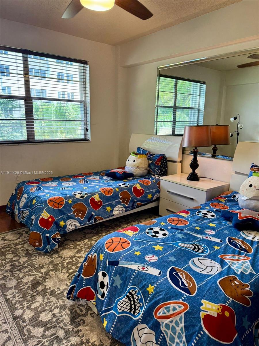 201 180th Drive, Unit 114 Sunny Isles Beach, FL 33160 - Photo 23 of 29 a bedroom with three beds and window