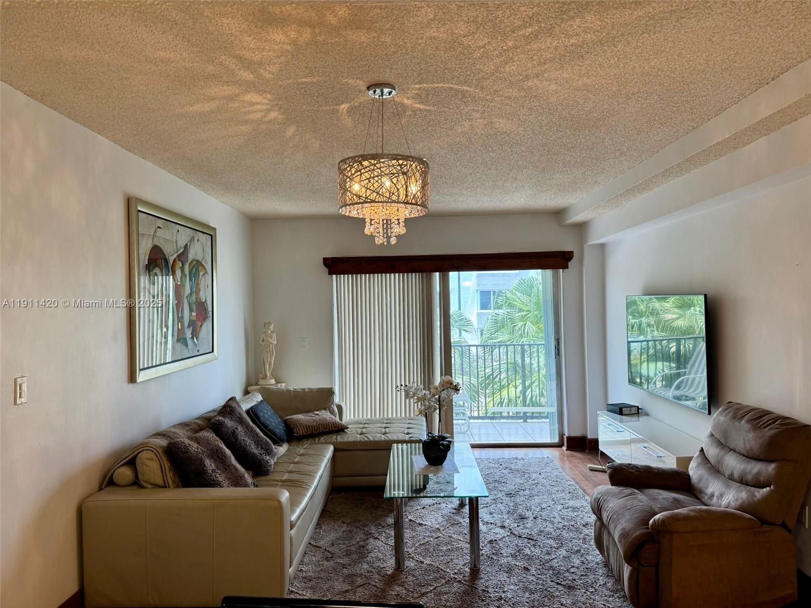 201 180th Drive, Unit 114 Sunny Isles Beach, FL 33160 - Photo 6 of 29 a living room with furniture and a window