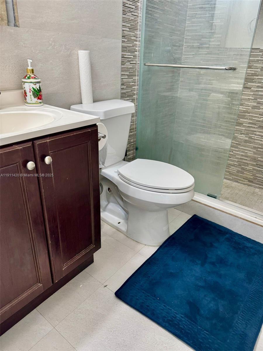 201 180th Drive, Unit 114 Sunny Isles Beach, FL 33160 - Photo 8 of 29 a bathroom with a sink a toilet and shower