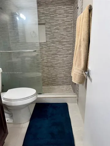 a bedroom with a bed and lamp on the dresser