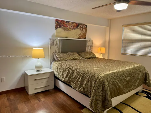 a bedroom with a bed and chair with the potted plant