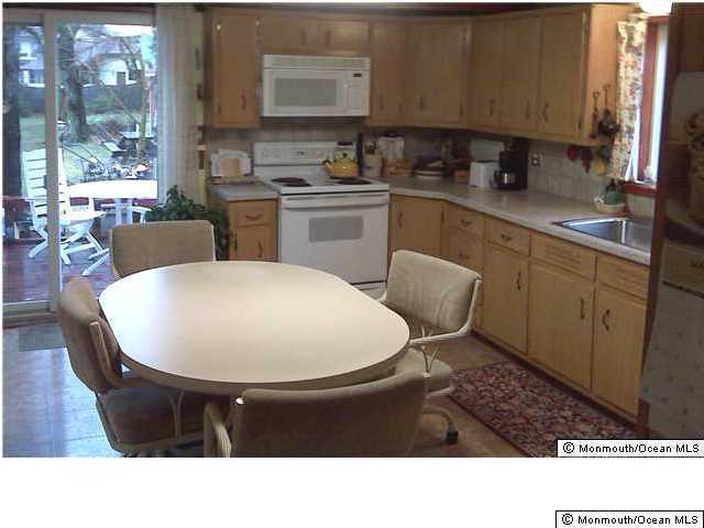 390 Bartley Road Jackson, NJ 08527 - Photo 2 of 3 a kitchen with a sink a stove and chairs