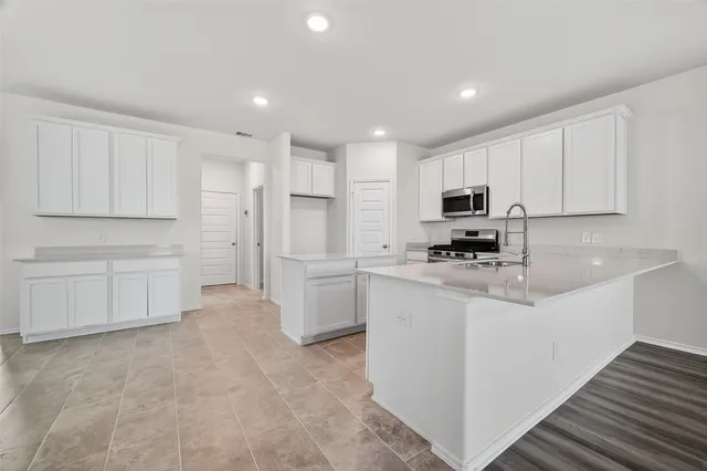a kitchen with white cabinets and stainless steel appliances