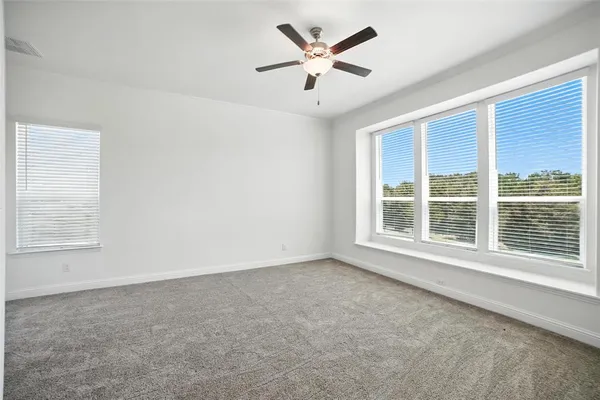 an empty room with a window and a ceiling fan