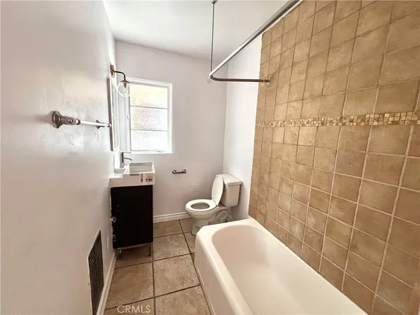 a bathroom with a sink a toilet a mirror and shower