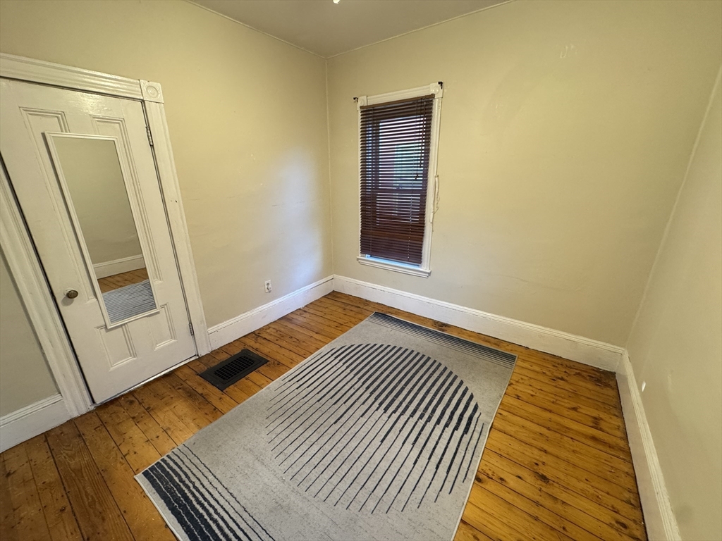 377 Highland Avenue, Unit 1 Somerville, MA 02144 - Photo 13 of 25 a view of a room with wooden floor and fence