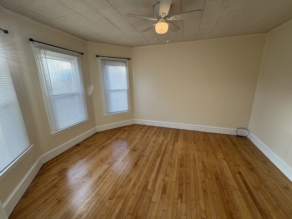 377 Highland Avenue, Unit 1 Somerville, MA 02144 - Photo 16 of 25 wooden floor in an empty room with a window