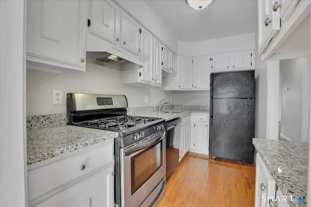 a kitchen with stainless steel appliances granite countertop a stove a refrigerator and a refrigerator