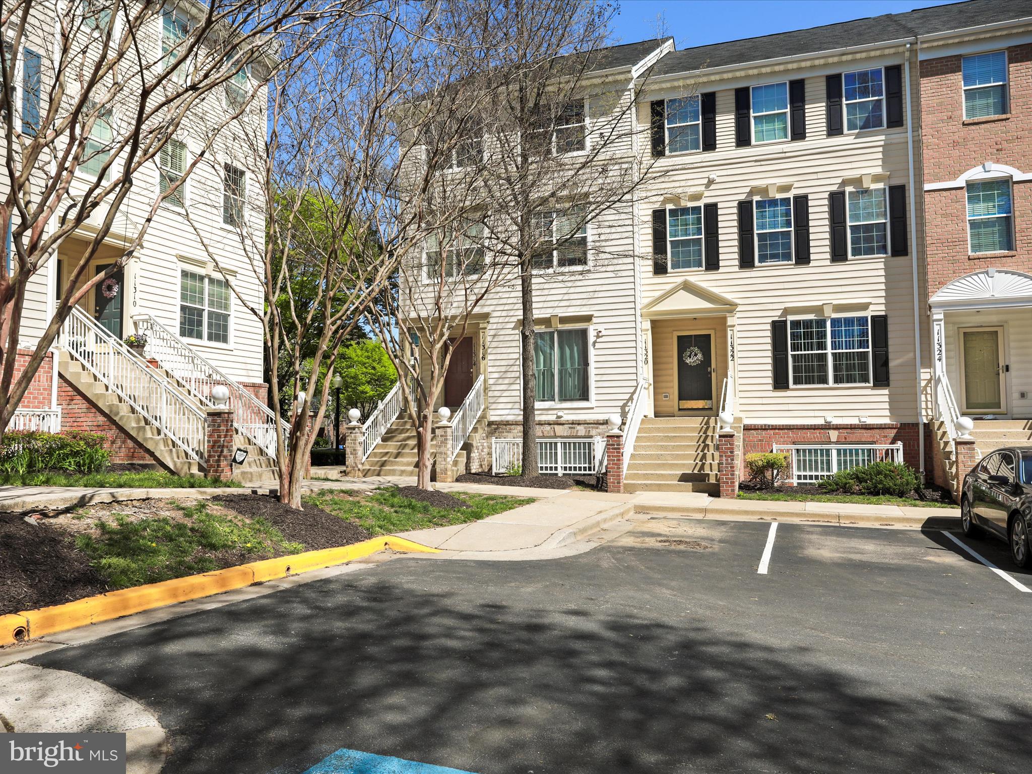 11312 King George Drive, Unit 4 Wheaton, MD 20902 - Photo 1 of 28 a view of a brick house with many windows and yard