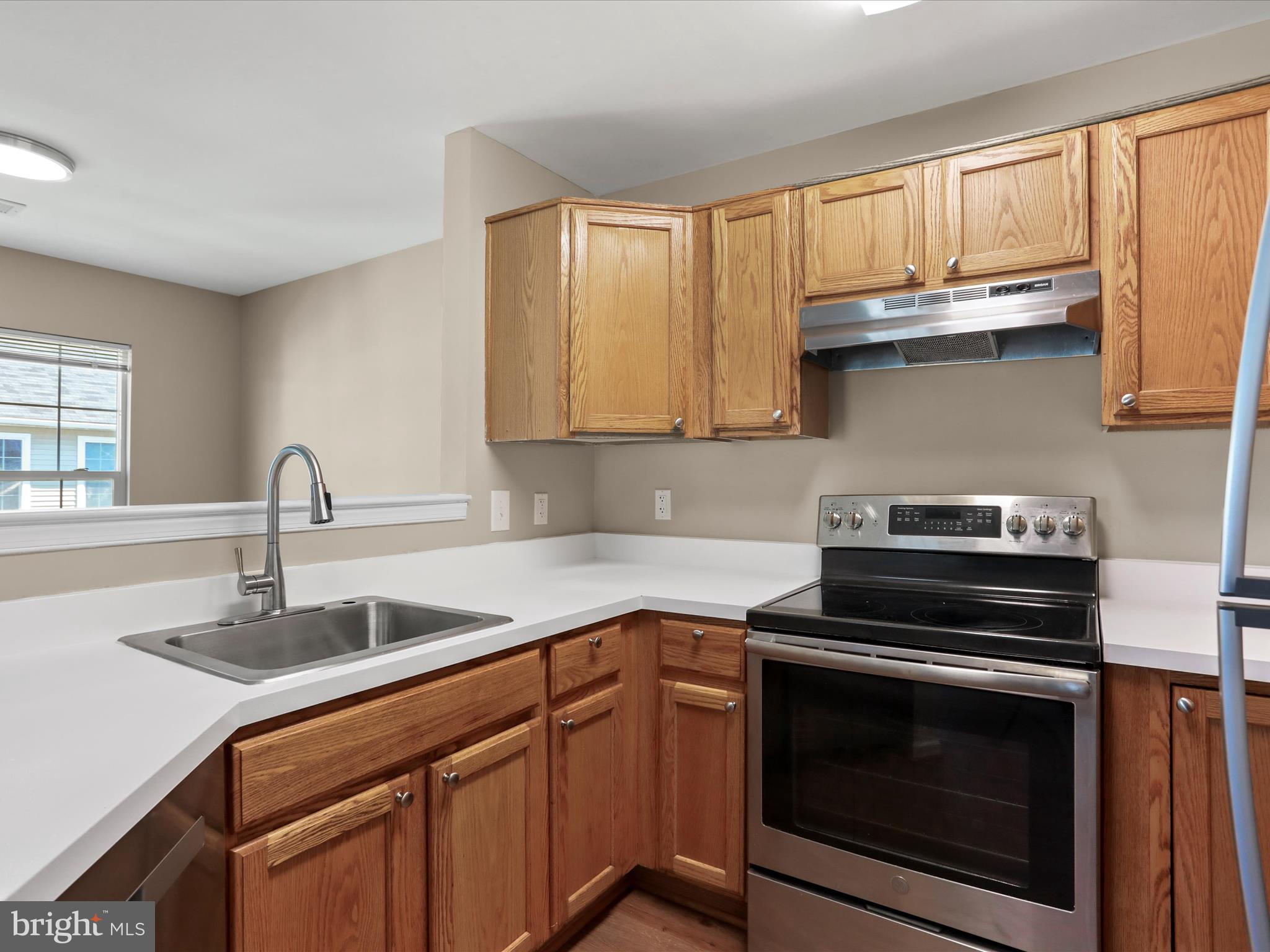11312 King George Drive, Unit 4 Wheaton, MD 20902 - Photo 11 of 28 a kitchen with a sink stove top oven and cabinets