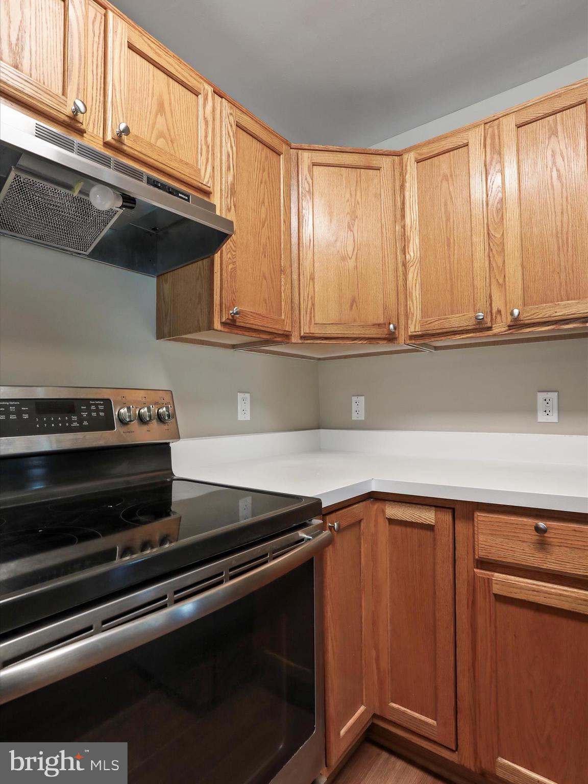 11312 King George Drive, Unit 4 Wheaton, MD 20902 - Photo 13 of 28 a kitchen with wooden cabinets and a stove top oven