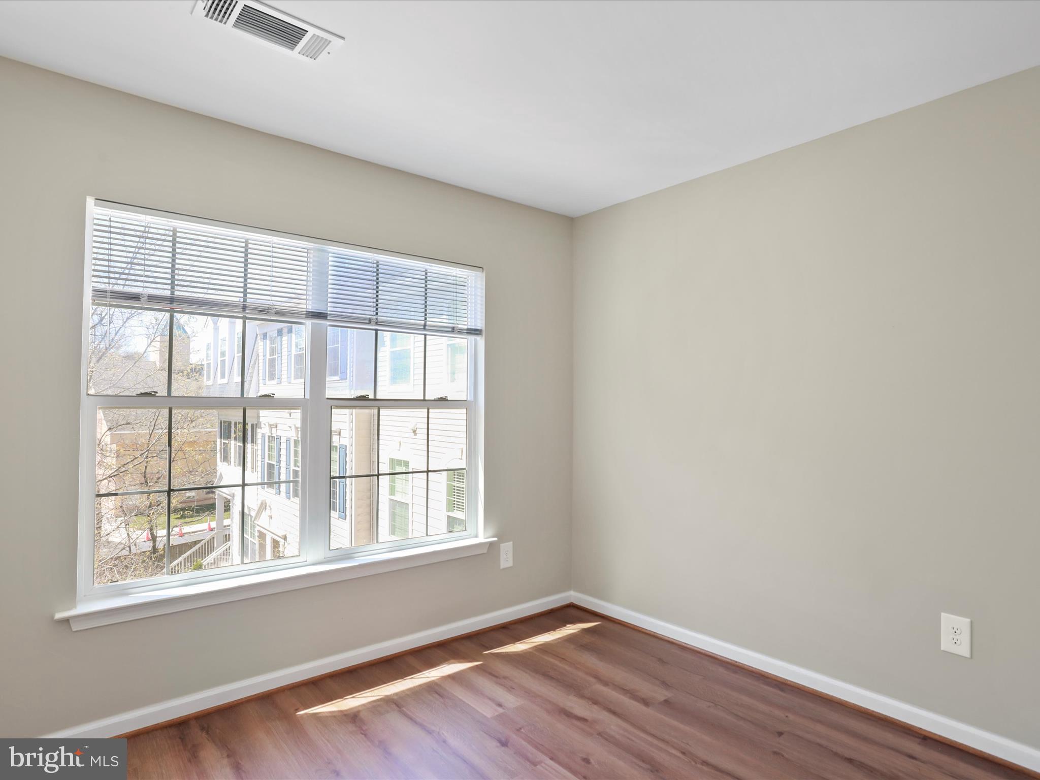 11312 King George Drive, Unit 4 Wheaton, MD 20902 - Photo 18 of 28 a view of an empty room with wooden floor and a window