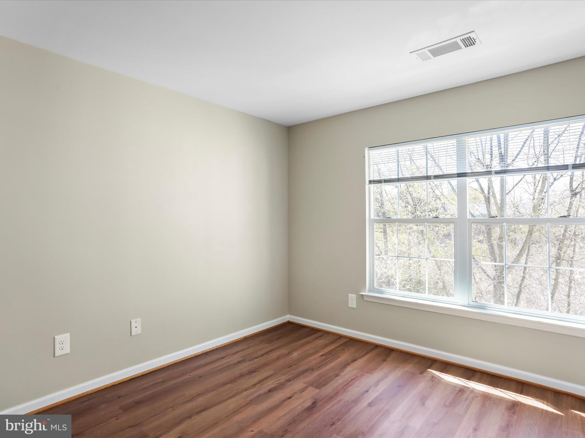 11312 King George Drive, Unit 4 Wheaton, MD 20902 - Photo 21 of 28 an empty room with wooden floor and windows