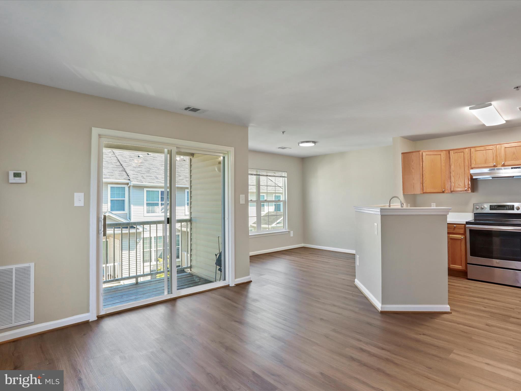11312 King George Drive, Unit 4 Wheaton, MD 20902 - Photo 7 of 28 a view of an empty room with a kitchen and wooden floor