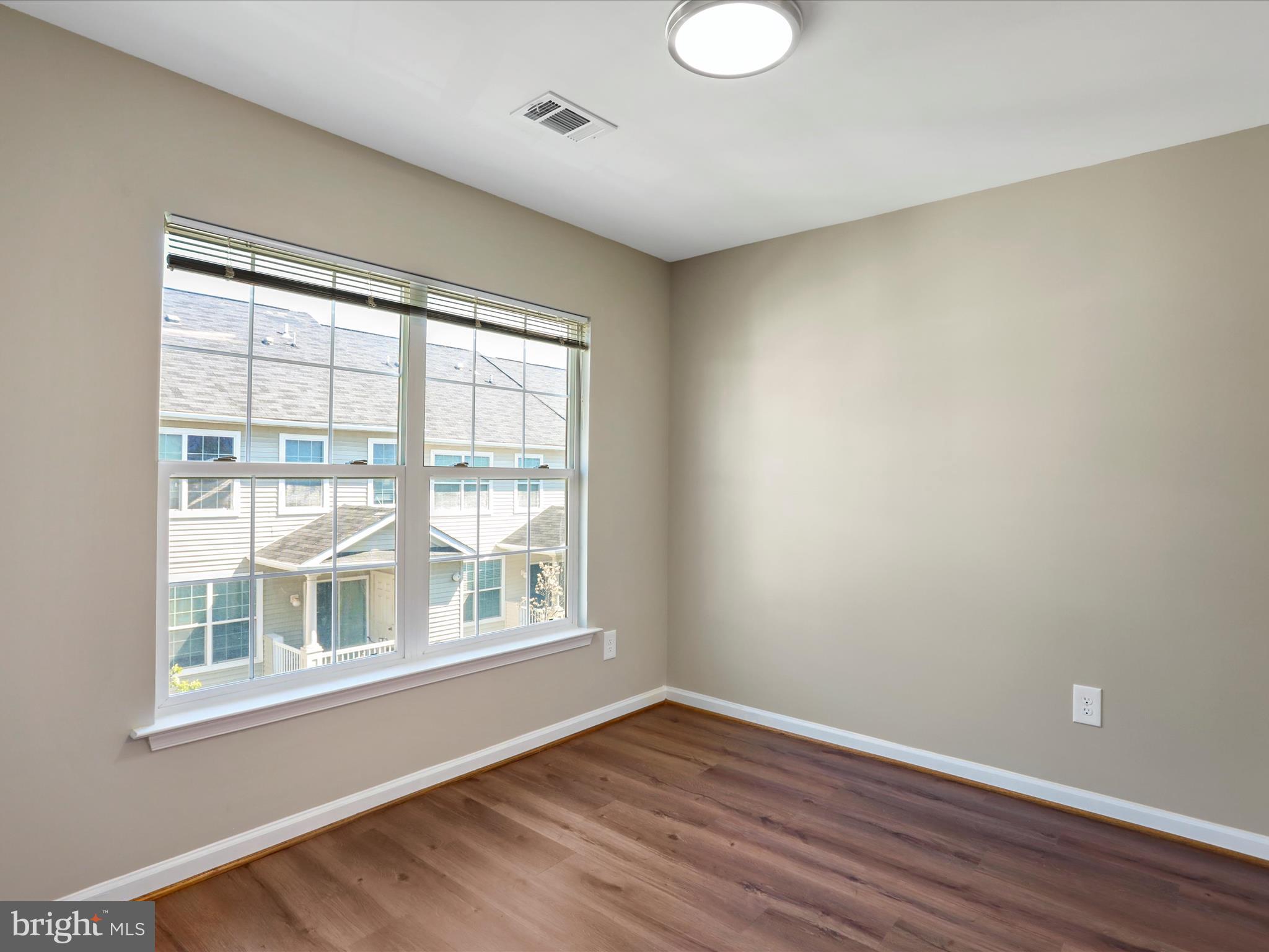 11312 King George Drive, Unit 4 Wheaton, MD 20902 - Photo 9 of 28 a view of an empty room with wooden floor and a window