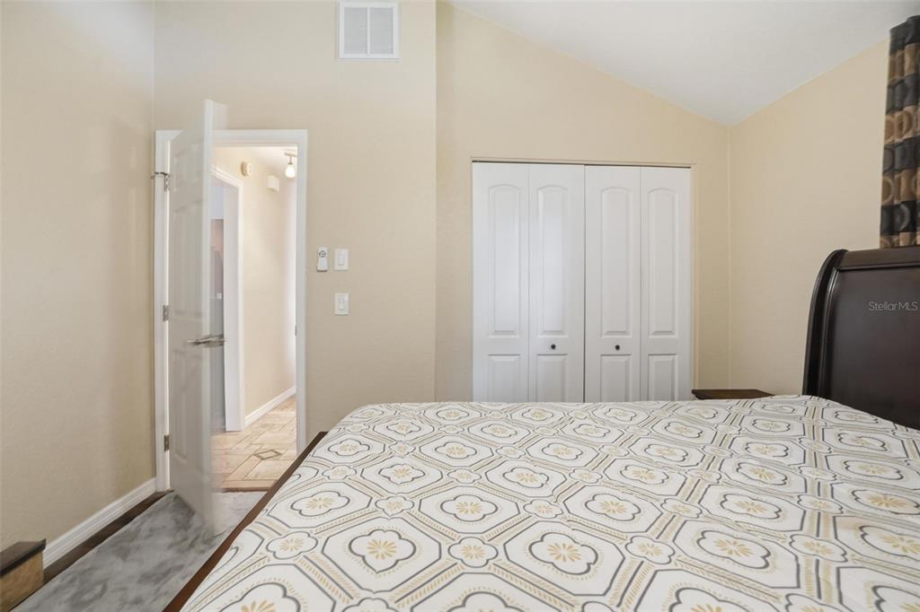 2658 Royal Ridge Drive Spring Hill, FL 34606 - Photo 14 of 38 a bedroom with a large bed and a chandelier