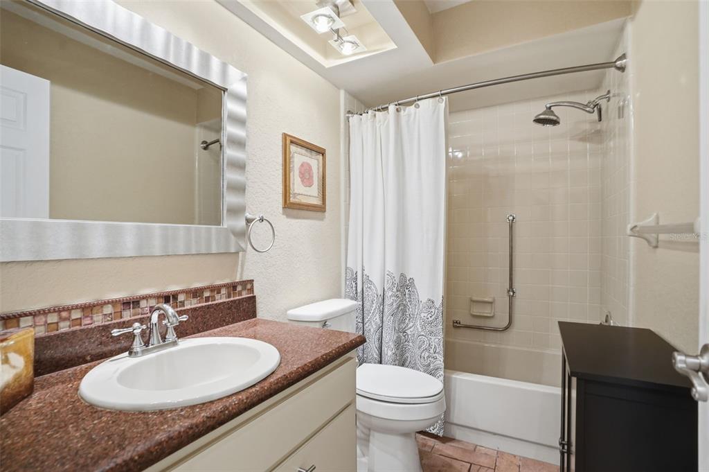 2658 Royal Ridge Drive Spring Hill, FL 34606 - Photo 17 of 38 a bathroom with a granite countertop sink toilet a mirror a vanity and shower