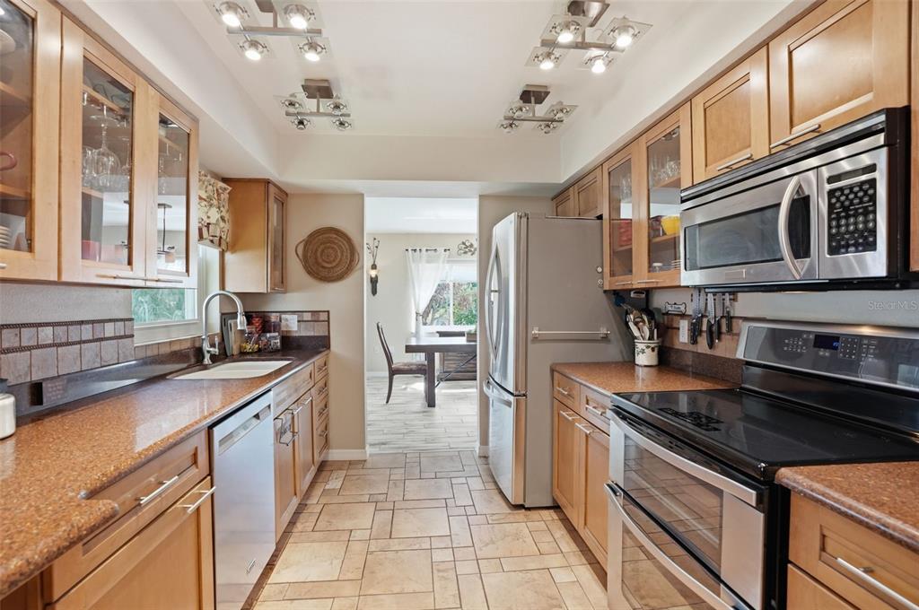 2658 Royal Ridge Drive Spring Hill, FL 34606 - Photo 3 of 38 a kitchen with stainless steel appliances granite countertop a sink stove and refrigerator