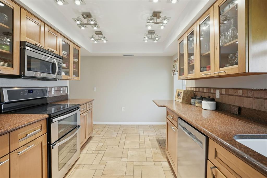 2658 Royal Ridge Drive Spring Hill, FL 34606 - Photo 36 of 38 a kitchen with stainless steel appliances granite countertop a sink and a stove