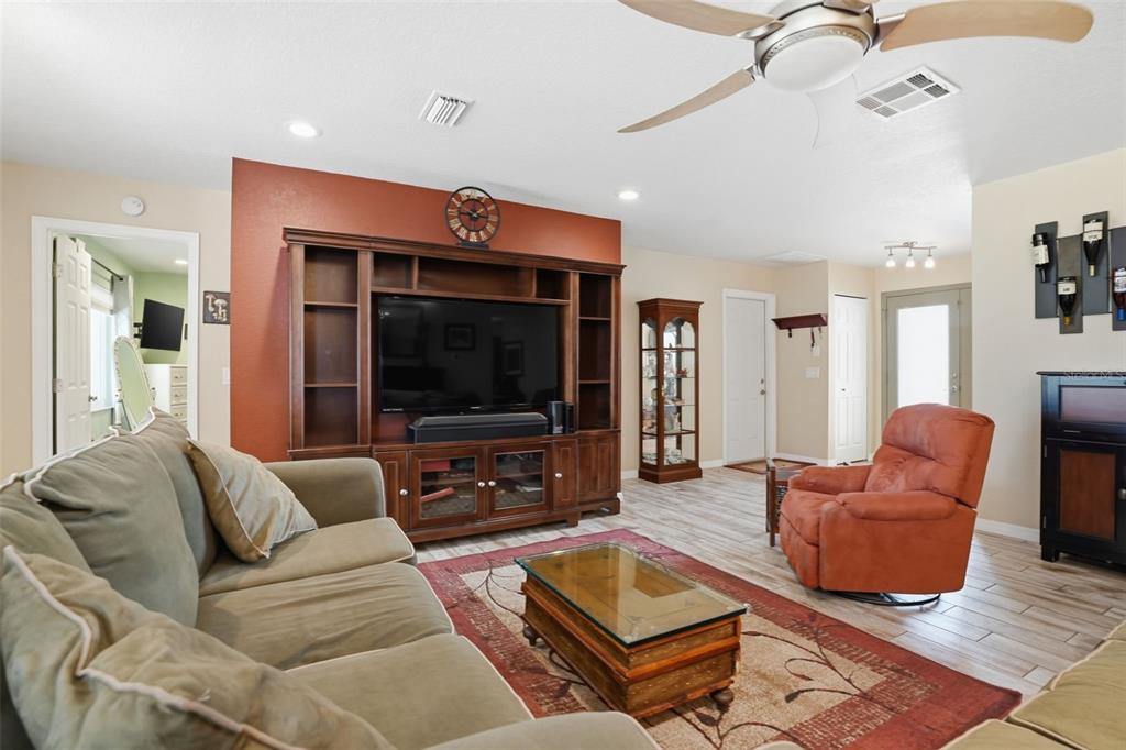 2658 Royal Ridge Drive Spring Hill, FL 34606 - Photo 6 of 38 a living room with furniture ceiling fan and a flat screen tv