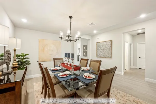 a view of a dining room with furniture a chandelier and wooden floor