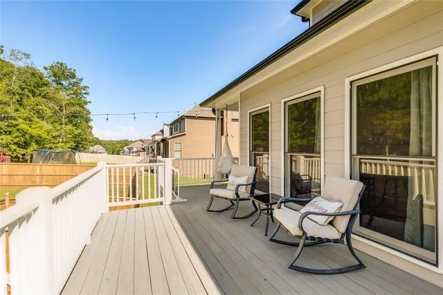 a balcony with wooden floor table and chairs
