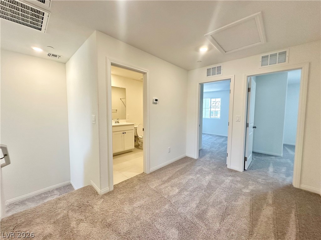 2121 Tricase Street Henderson, NV 89044 - Photo 21 of 31 Unfurnished room featuring light colored carpet, a sink, and baseboards