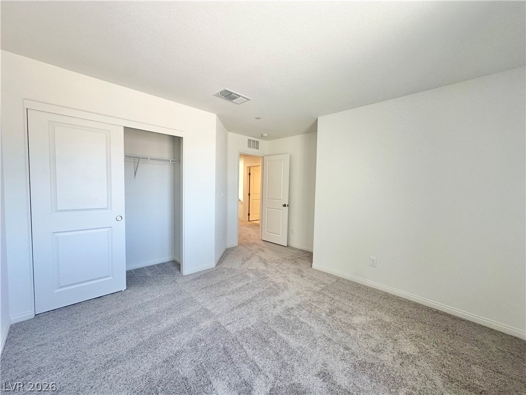 2121 Tricase Street Henderson, NV 89044 - Photo 29 of 31 Unfurnished bedroom with light carpet, baseboards, and a closet