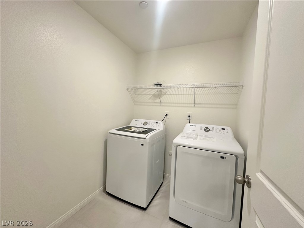 2121 Tricase Street Henderson, NV 89044 - Photo 8 of 31 Laundry area featuring washer and clothes dryer, baseboards, and light tile patterned floors