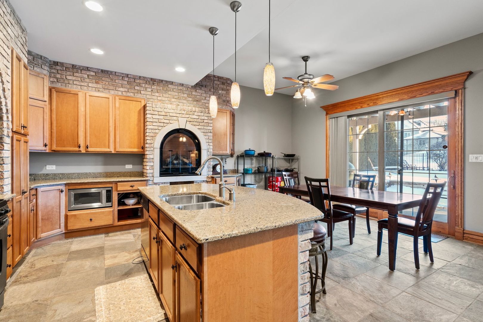 109 Singletree Road Orland Park, IL 60467 - Photo 47 of 66 a kitchen with a stove a sink a microwave a dining table and chairs