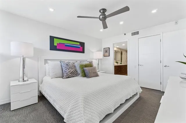 a spacious bedroom with a bed and a lamp