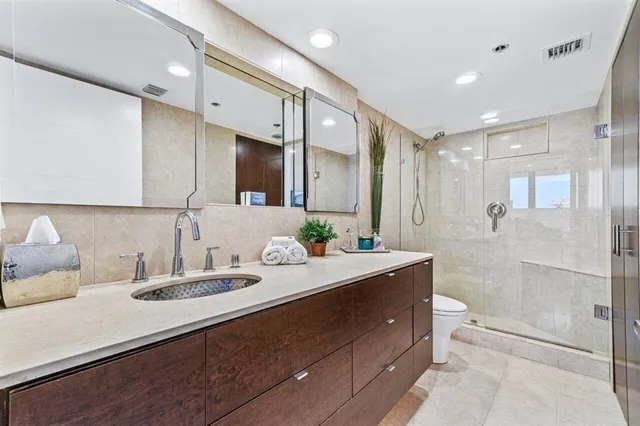 a bathroom with a double vanity sink mirror and shower