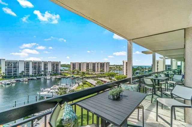 a view of a balcony with dining table and chairs