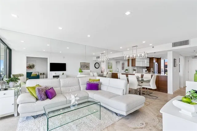 a living room with furniture and view of kitchen