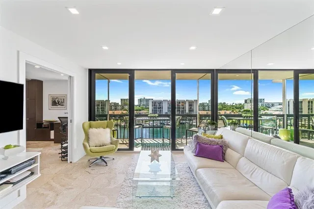 a living room with furniture tv and a floor to ceiling window