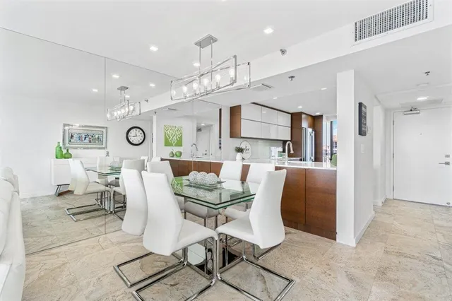 a kitchen with kitchen island stainless steel appliances a dining table and chairs
