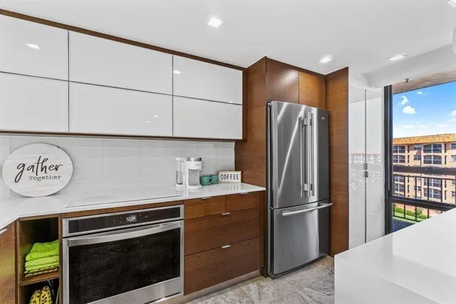 a kitchen with stainless steel appliances granite countertop a refrigerator and a stove top oven