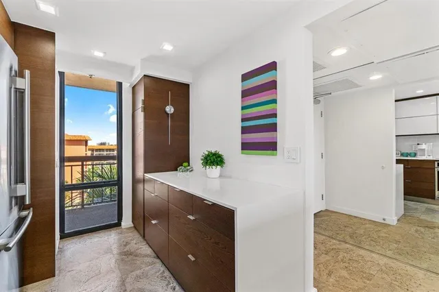 a kitchen with stainless steel appliances kitchen island granite countertop a refrigerator and a sink