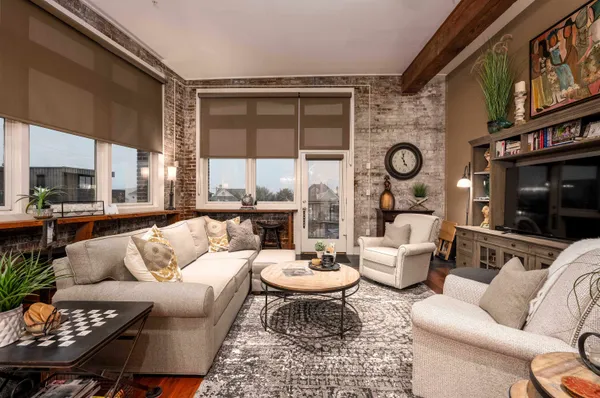 a living room with furniture a rug and a large window