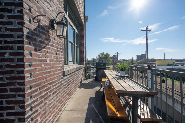 a balcony with chairs and wooden fence