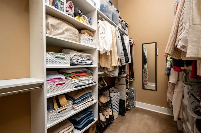 a view of walk in closet with clothes and shoes